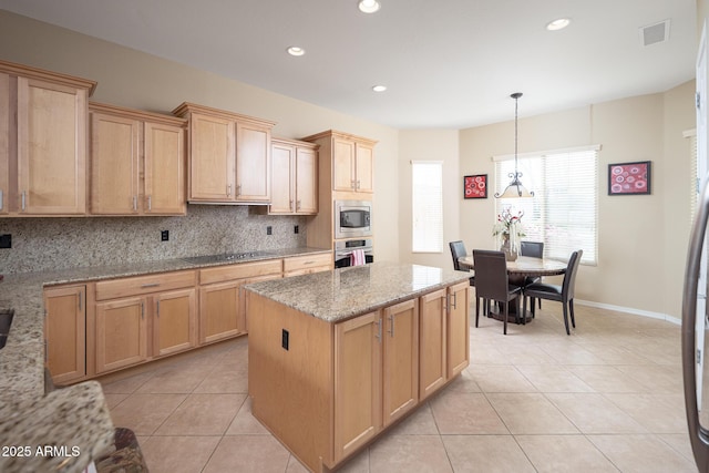 kitchen featuring appliances with stainless steel finishes, a center island, light stone countertops, decorative backsplash, and decorative light fixtures