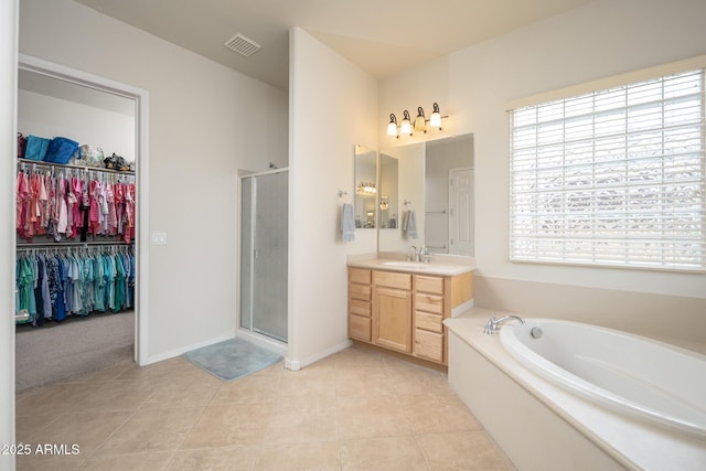 bathroom with vanity, tile patterned flooring, and plus walk in shower