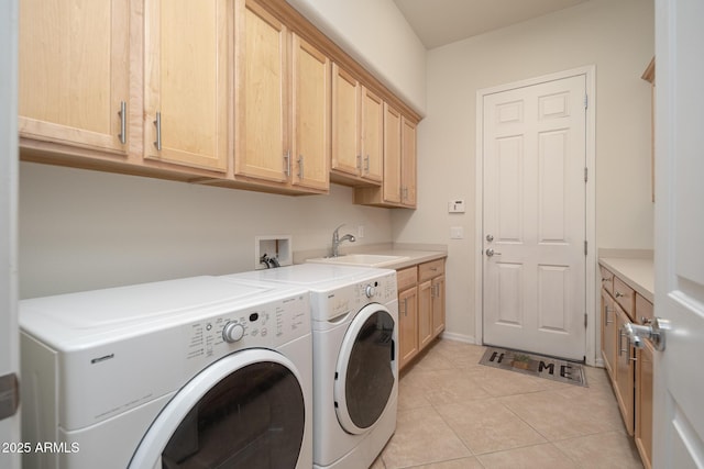 laundry room featuring light tile patterned flooring, cabinets, separate washer and dryer, and sink