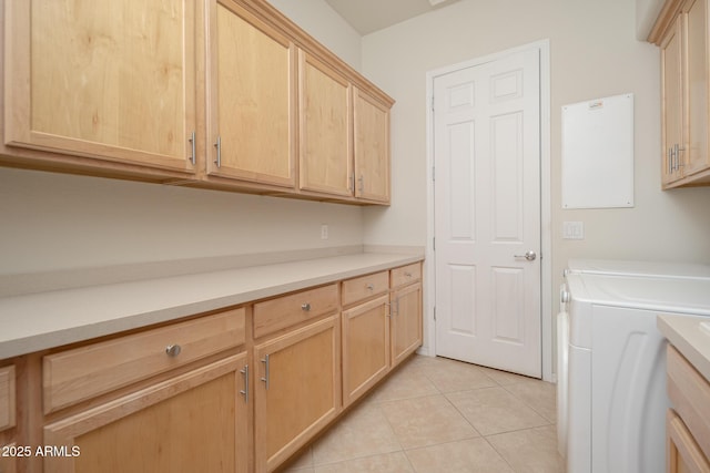 laundry room with cabinets, light tile patterned floors, and washer and clothes dryer