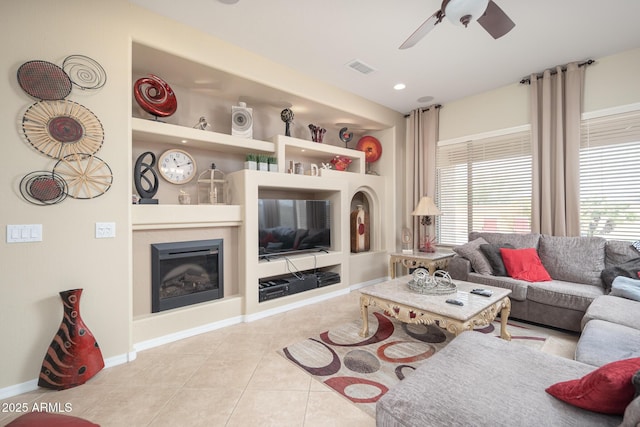 tiled living room with plenty of natural light, built in features, and ceiling fan