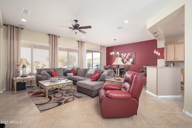 living room with ceiling fan with notable chandelier and light tile patterned floors