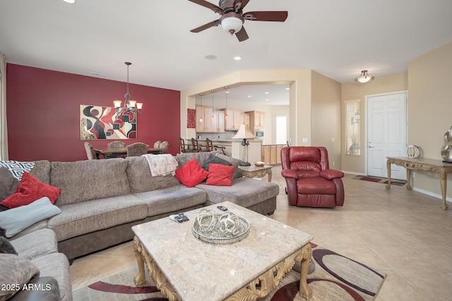 living room with light tile patterned flooring and ceiling fan with notable chandelier