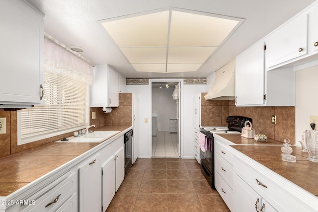 11109 W Granada Dr, Sun City, AZ 85373 - kitchen featuring custom exhaust hood, white cabinetry, a sink, dark tile patterned flooring, and black appliances