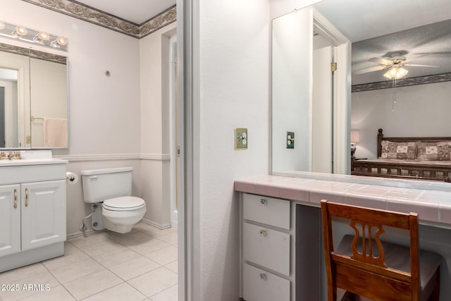 11109 W Granada Dr, Sun City, AZ 85373 - bathroom with vanity, toilet, tile patterned flooring, and a ceiling fan