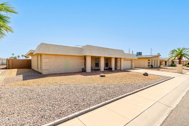 11109 W Granada Dr, Sun City, AZ 85373 - view of front facade with fence, driveway, stucco siding, and an attached garage