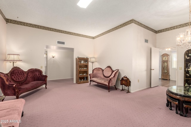 11109 W Granada Dr, Sun City, AZ 85373 - carpeted living room featuring a notable chandelier, crown molding, baseboards, and visible vents