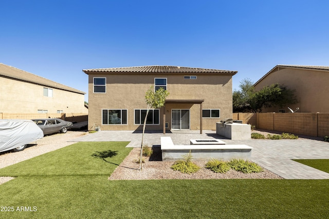 back of property with a patio area, a lawn, and exterior kitchen