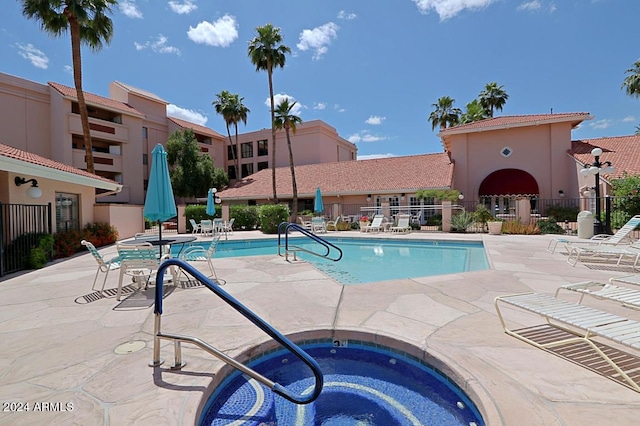 view of swimming pool with a community hot tub and a patio area