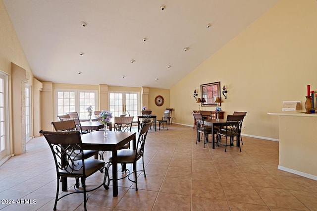 tiled dining space featuring high vaulted ceiling