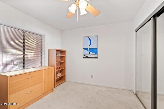 carpeted bedroom featuring ceiling fan and a closet