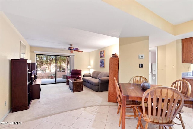 carpeted dining area with ceiling fan