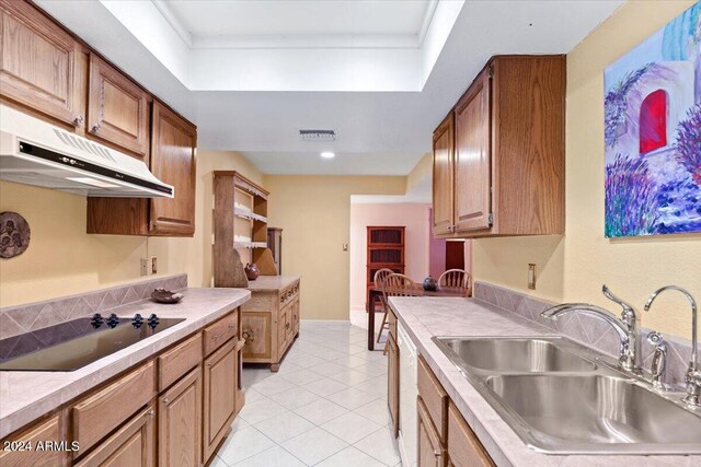 kitchen featuring light tile patterned floors, sink, dishwasher, a tray ceiling, and black electric stovetop