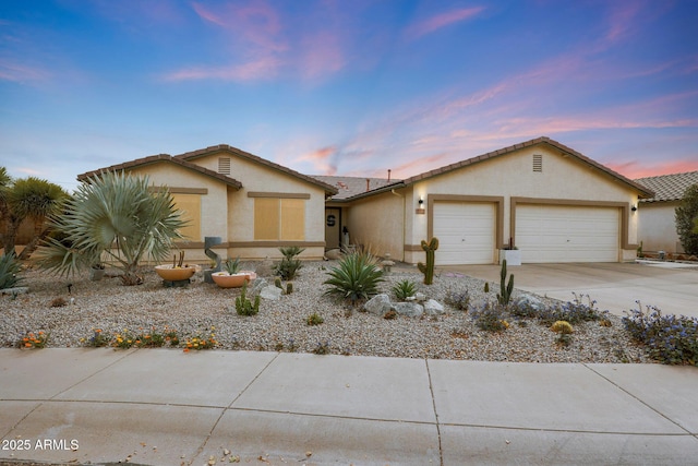 view of front of home with driveway, an attached garage, and stucco siding