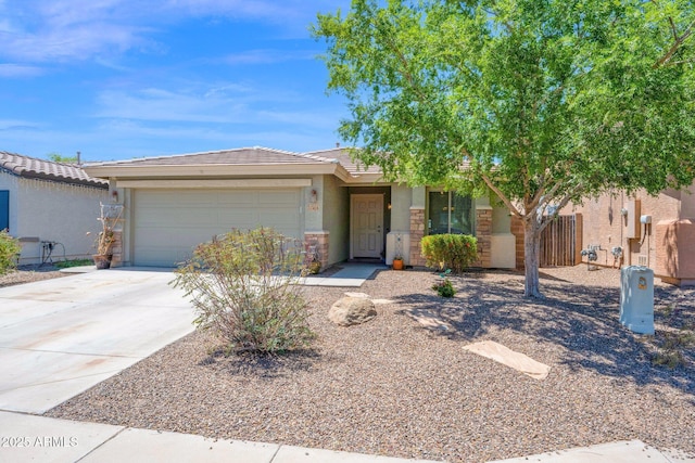 ranch-style house featuring a tiled roof, concrete driveway, an attached garage, stone siding, and stucco siding