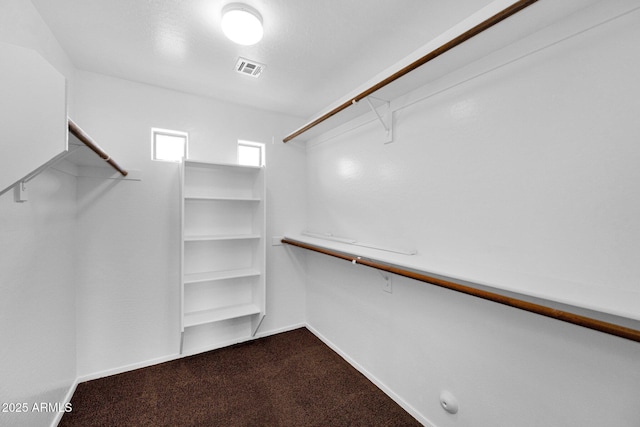 walk in closet with dark carpet and visible vents