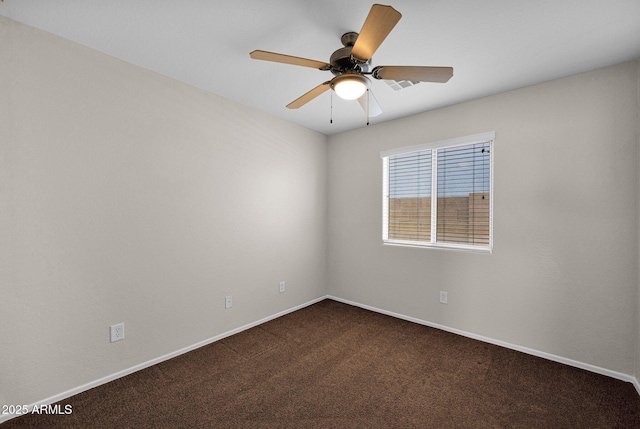 unfurnished room with baseboards, ceiling fan, and dark carpet