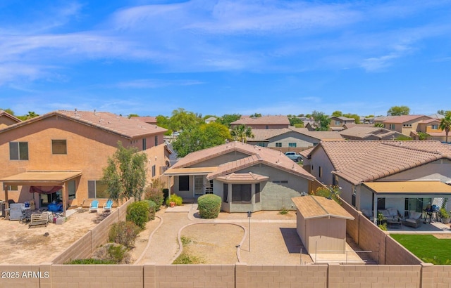 back of property with a residential view, a shed, a fenced backyard, a patio area, and an outdoor structure