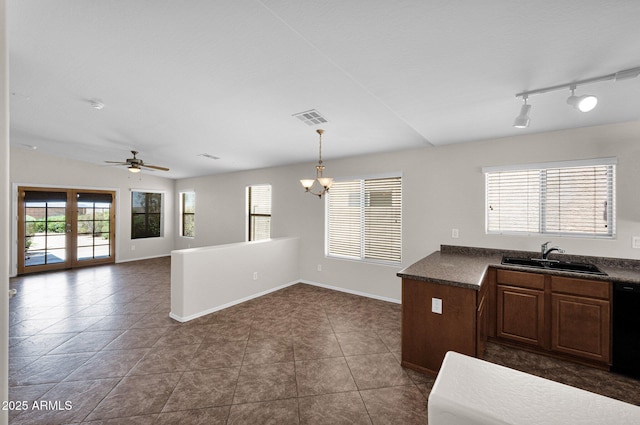 kitchen featuring dark countertops, visible vents, a sink, and ceiling fan with notable chandelier
