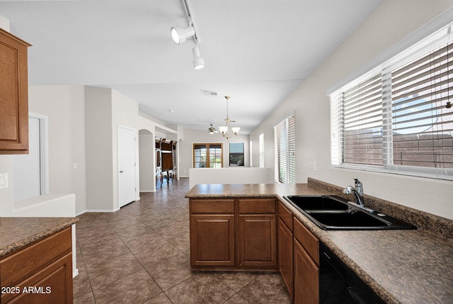 kitchen featuring visible vents, dark countertops, a sink, a peninsula, and a chandelier