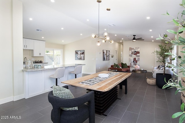 dining space featuring lofted ceiling, sink, and dark tile patterned floors