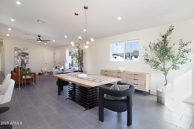 dining room with vaulted ceiling, dark tile patterned flooring, and ceiling fan