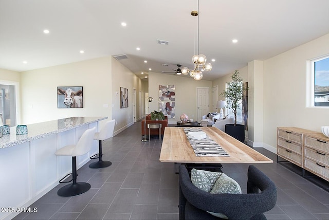 dining room with dark tile patterned flooring and vaulted ceiling