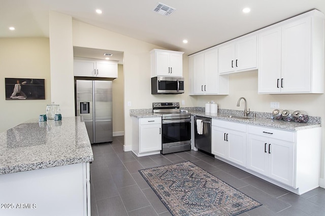 kitchen with white cabinetry, light stone counters, and stainless steel appliances