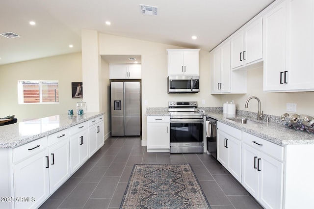 kitchen with vaulted ceiling, white cabinetry, sink, kitchen peninsula, and stainless steel appliances