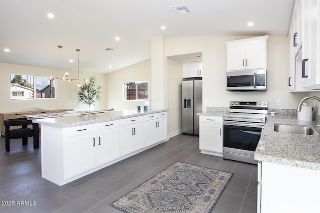 kitchen with decorative light fixtures, sink, white cabinets, stainless steel appliances, and light stone countertops