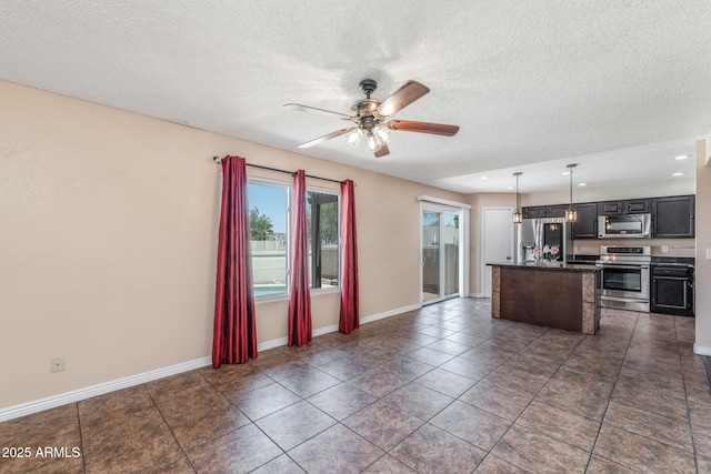 4114 E Muirwood Dr, Phoenix, AZ 85048 - kitchen with appliances with stainless steel finishes, ceiling fan, a center island, dark countertops, and hanging light fixtures