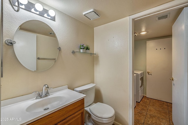 4114 E Muirwood Dr, Phoenix, AZ 85048 - bathroom with washer and clothes dryer, toilet, vanity, and tile patterned flooring