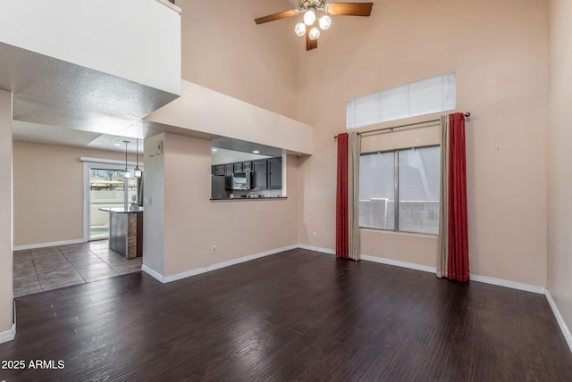 4114 E Muirwood Dr, Phoenix, AZ 85048 - unfurnished living room featuring ceiling fan, dark wood-style flooring, and baseboards