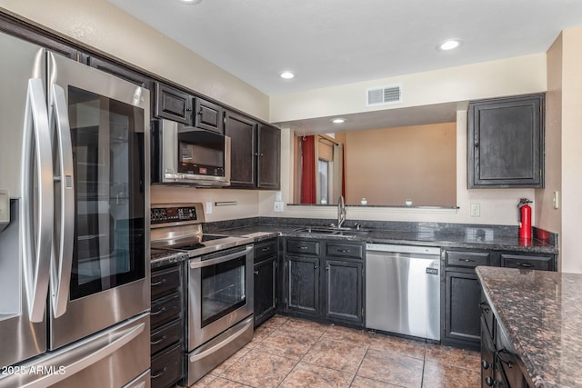 4114 E Muirwood Dr, Phoenix, AZ 85048 - kitchen featuring appliances with stainless steel finishes, a sink, dark stone counters, and recessed lighting