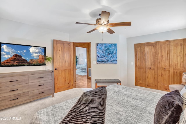 bedroom featuring ceiling fan, light colored carpet, and a closet