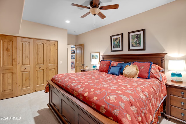 bedroom featuring ceiling fan, light colored carpet, and a closet