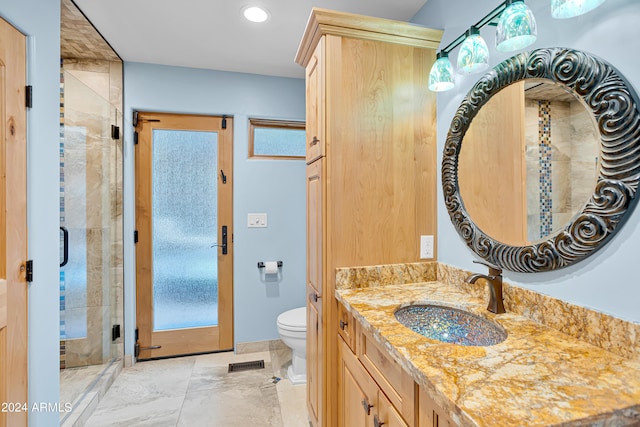 bathroom with vanity, toilet, and an enclosed shower