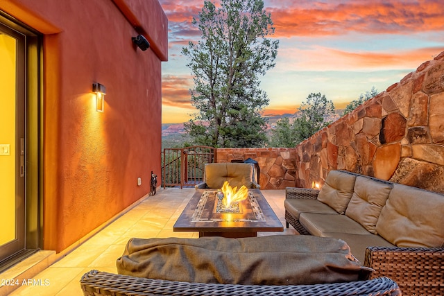 patio terrace at dusk featuring an outdoor living space with a fire pit