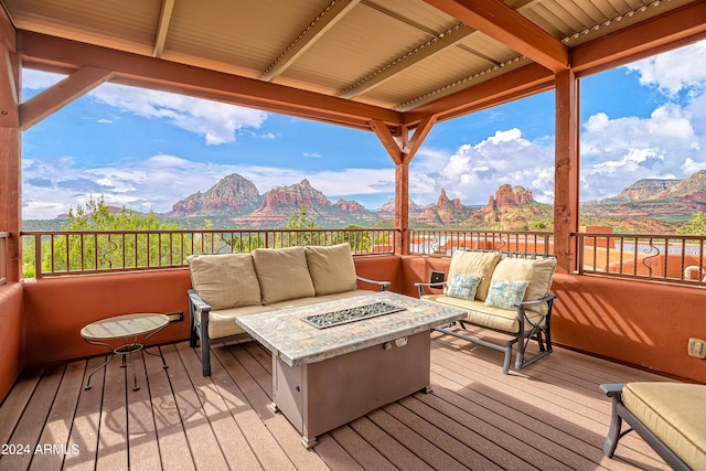 wooden deck with a mountain view and an outdoor living space with a fire pit