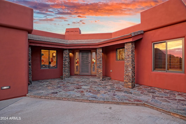 exterior entry at dusk with a patio