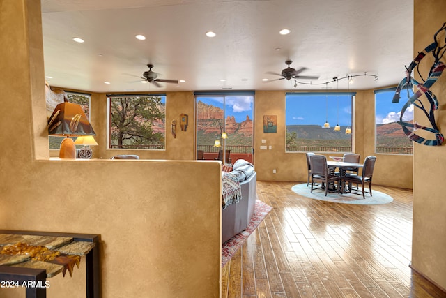 living room with hardwood / wood-style flooring, ceiling fan, and rail lighting