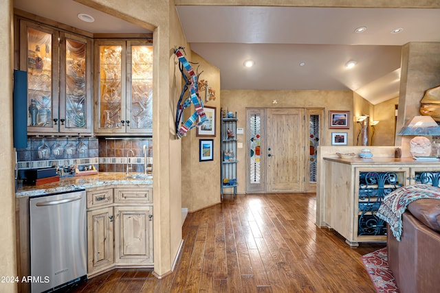 kitchen with lofted ceiling, dark hardwood / wood-style floors, dishwasher, light stone countertops, and decorative backsplash