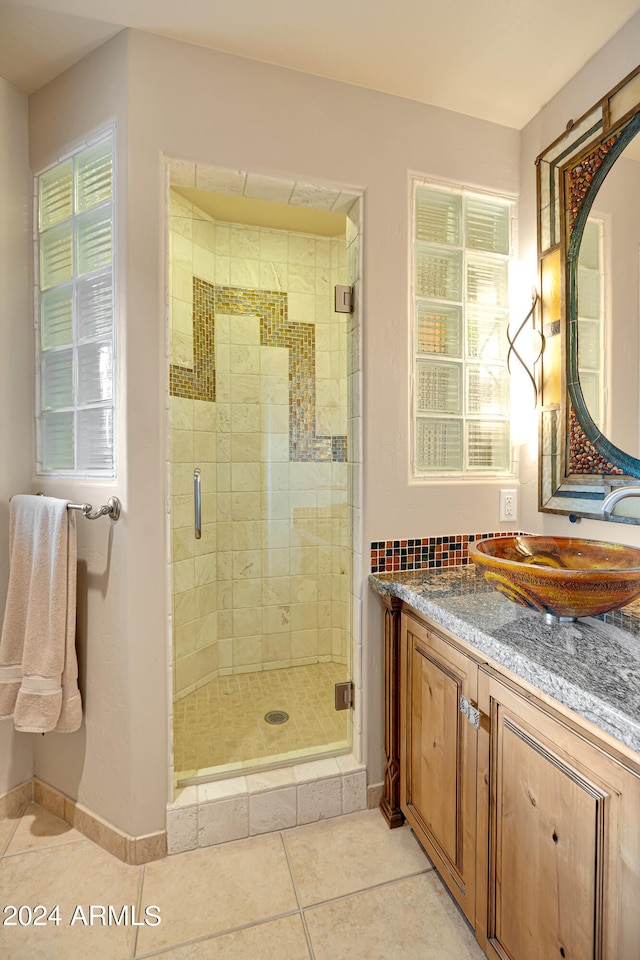 bathroom with vanity, a shower with shower door, and tile patterned floors