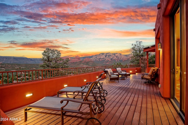 deck at dusk featuring an outdoor living space and a mountain view