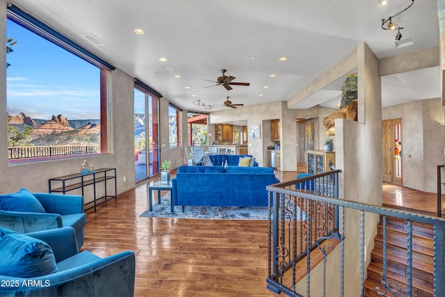 living room featuring ceiling fan, wood-type flooring, and a mountain view