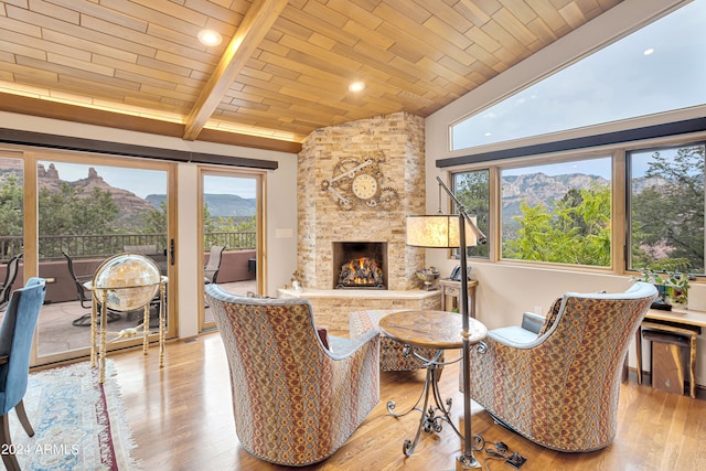 living room featuring a mountain view, vaulted ceiling with beams, and light wood-type flooring