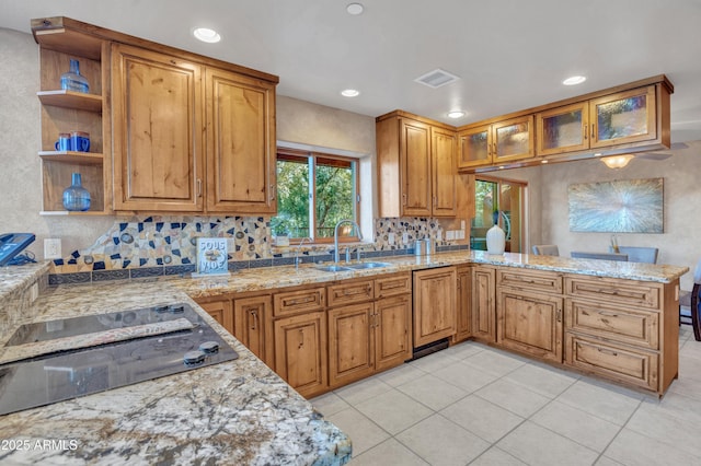 kitchen featuring light stone counters, dishwashing machine, black electric cooktop, and kitchen peninsula