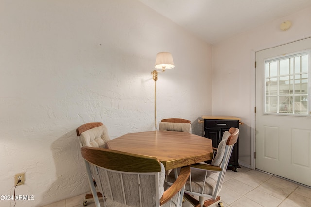 dining room featuring vaulted ceiling and light tile patterned floors