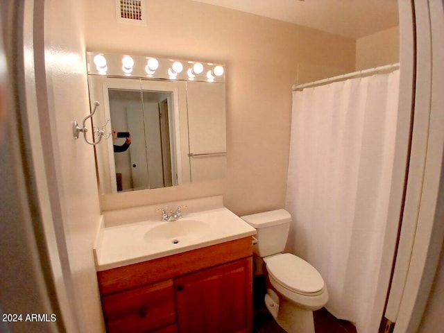 bathroom featuring toilet and vanity