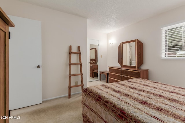 bedroom with light carpet and a textured ceiling